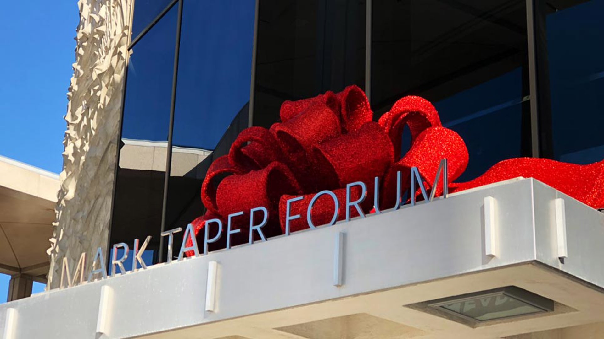 The Mark Taper Forum marquee with a red bow on top. 