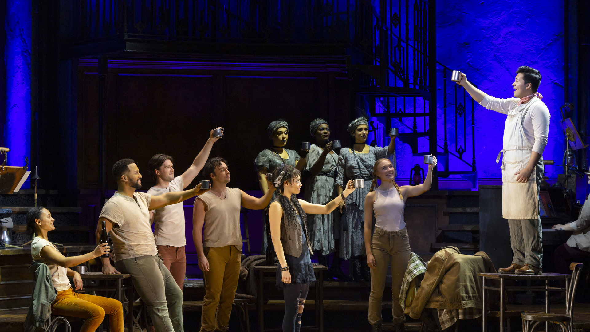 The cast of Hadestown cheers. 