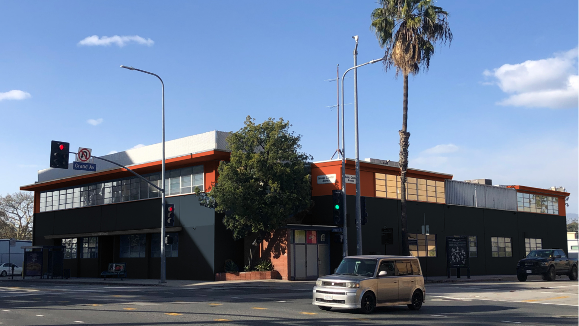 A office building with dark tones and orange highlight sits at the intersection of Grand Ave. and Temple St.