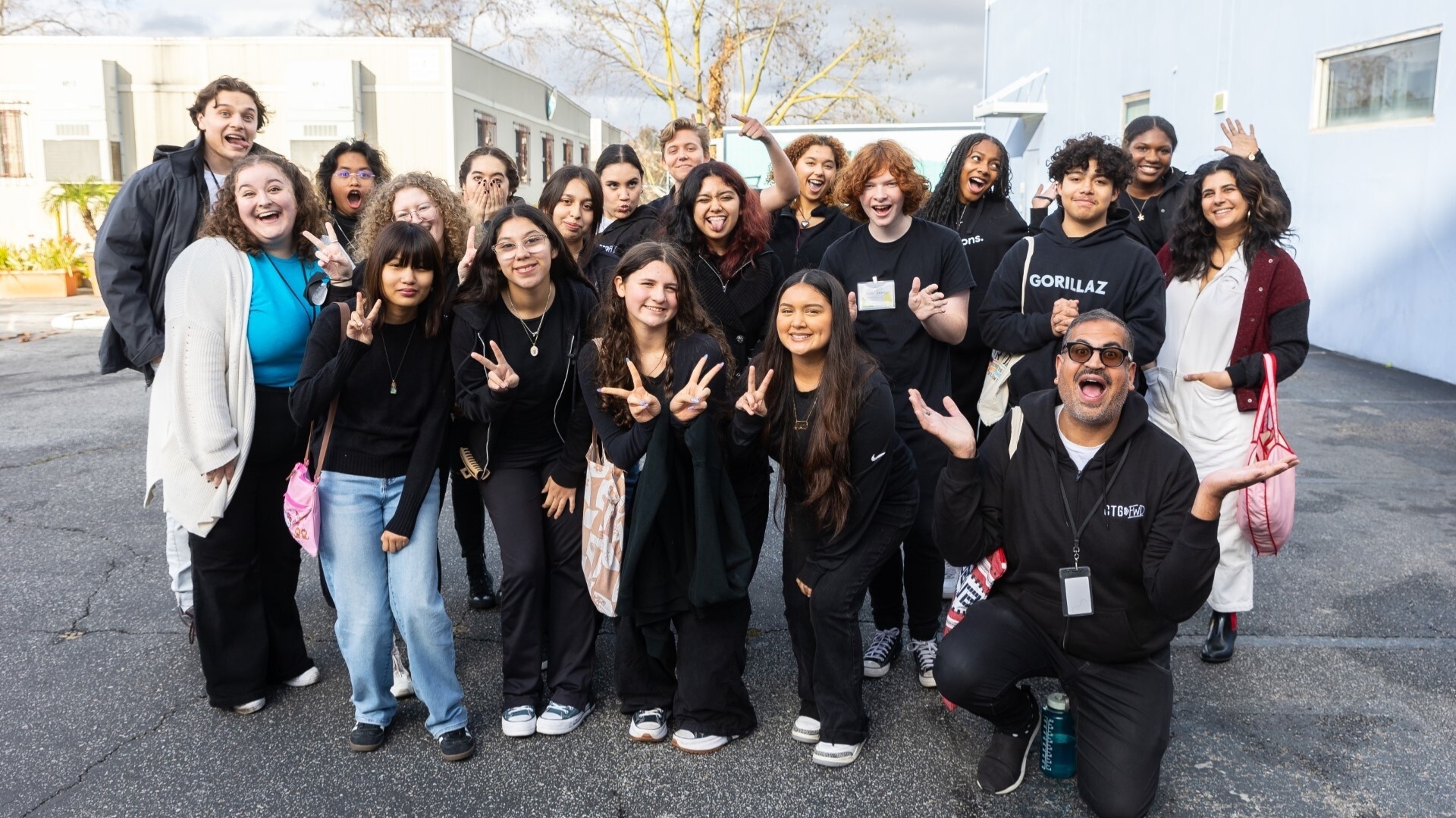 A group of student ambasadors take a group with Education Staff making fun poses. 