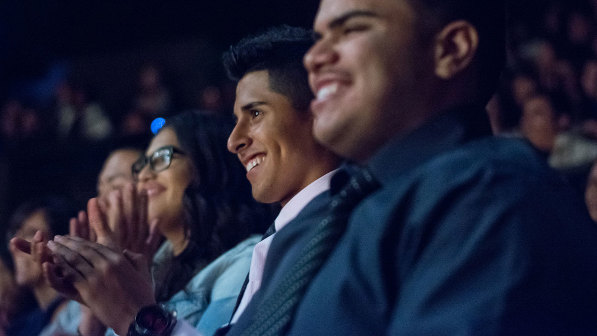 Students (6th-12th Grade) sit inside the Ahmanson Theatre applauding during a performance.