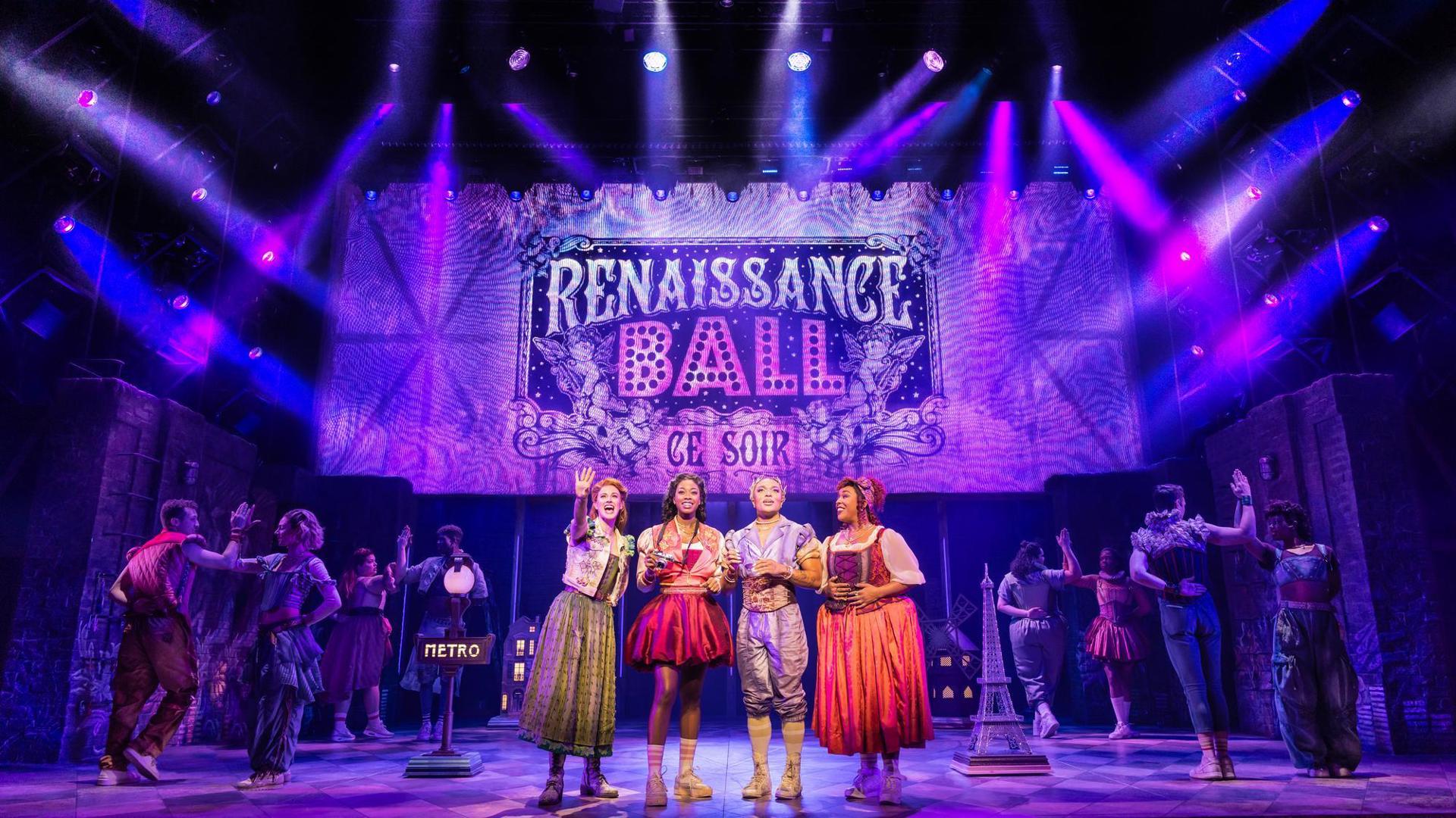 Teal Wicks, Rachel Simone Webb, Nick Drake and Kathryn Allison stand center stage beneath a sign that reads "Renaissance Ball'.