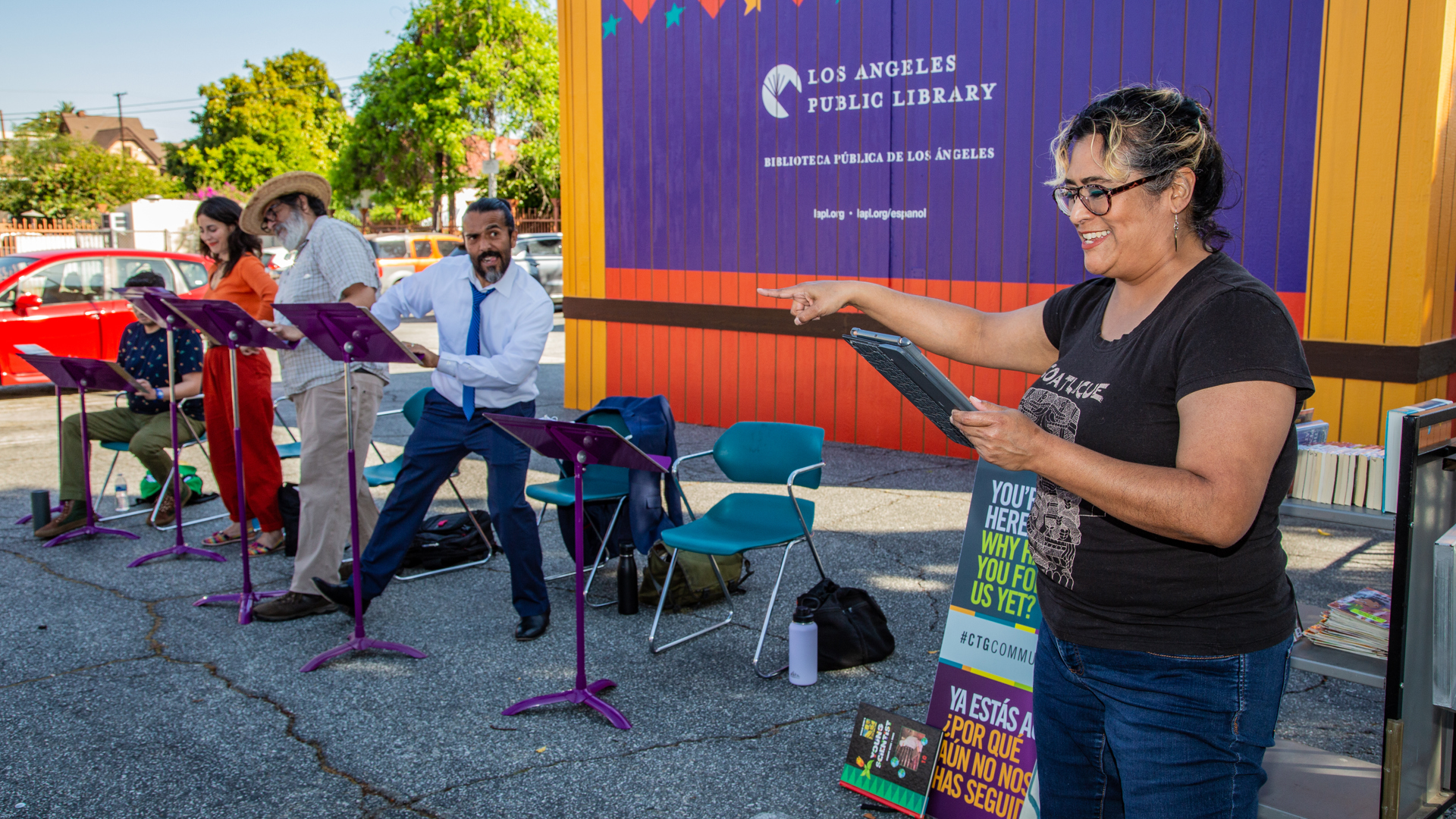 Four actors perform a reading of a play outdoors.