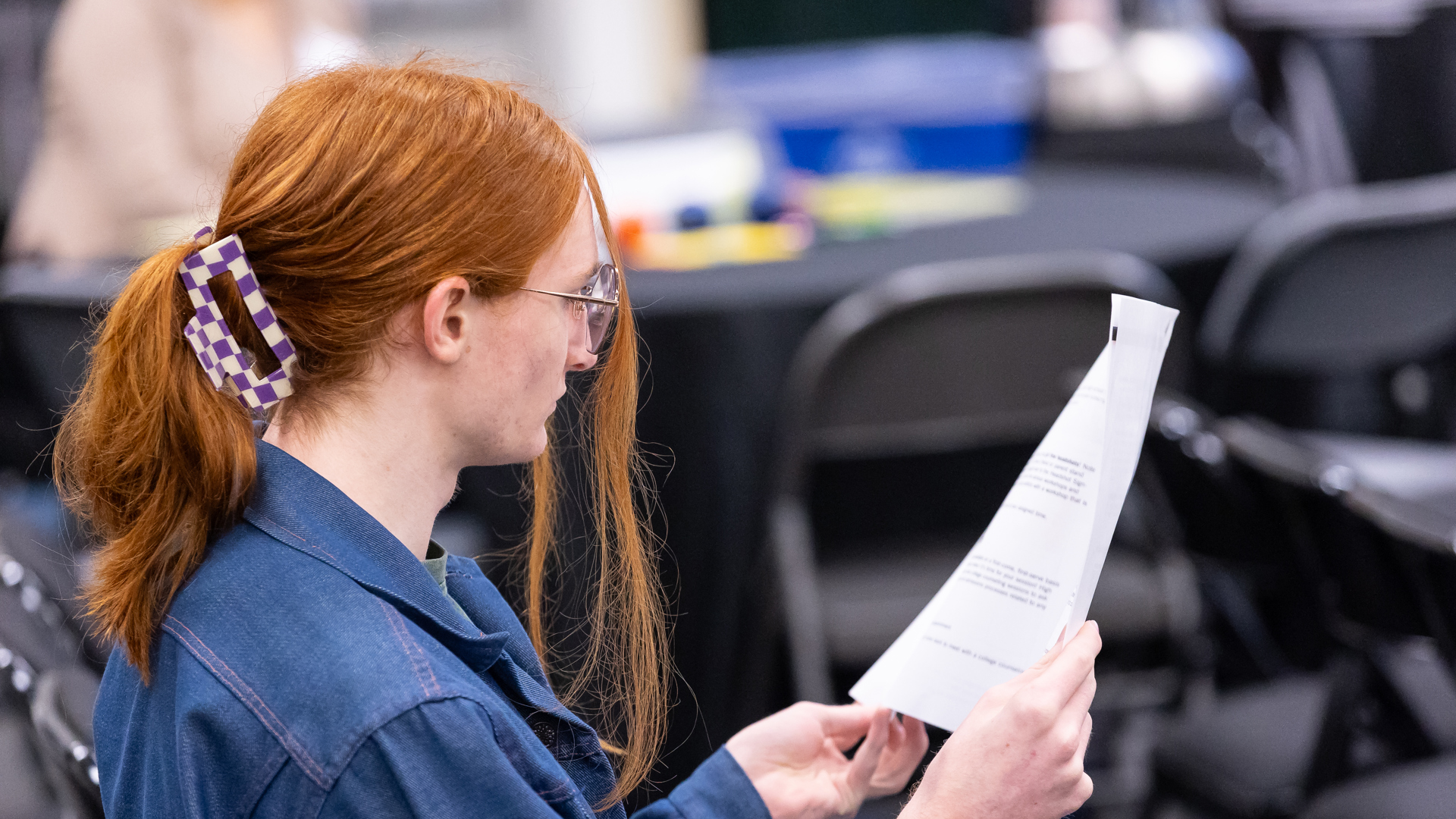 A person is holding and reviewing a script. 